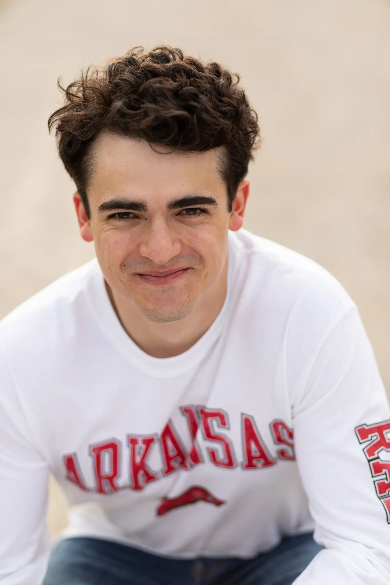 Senior in an Arkansas shirt grinning at the camera