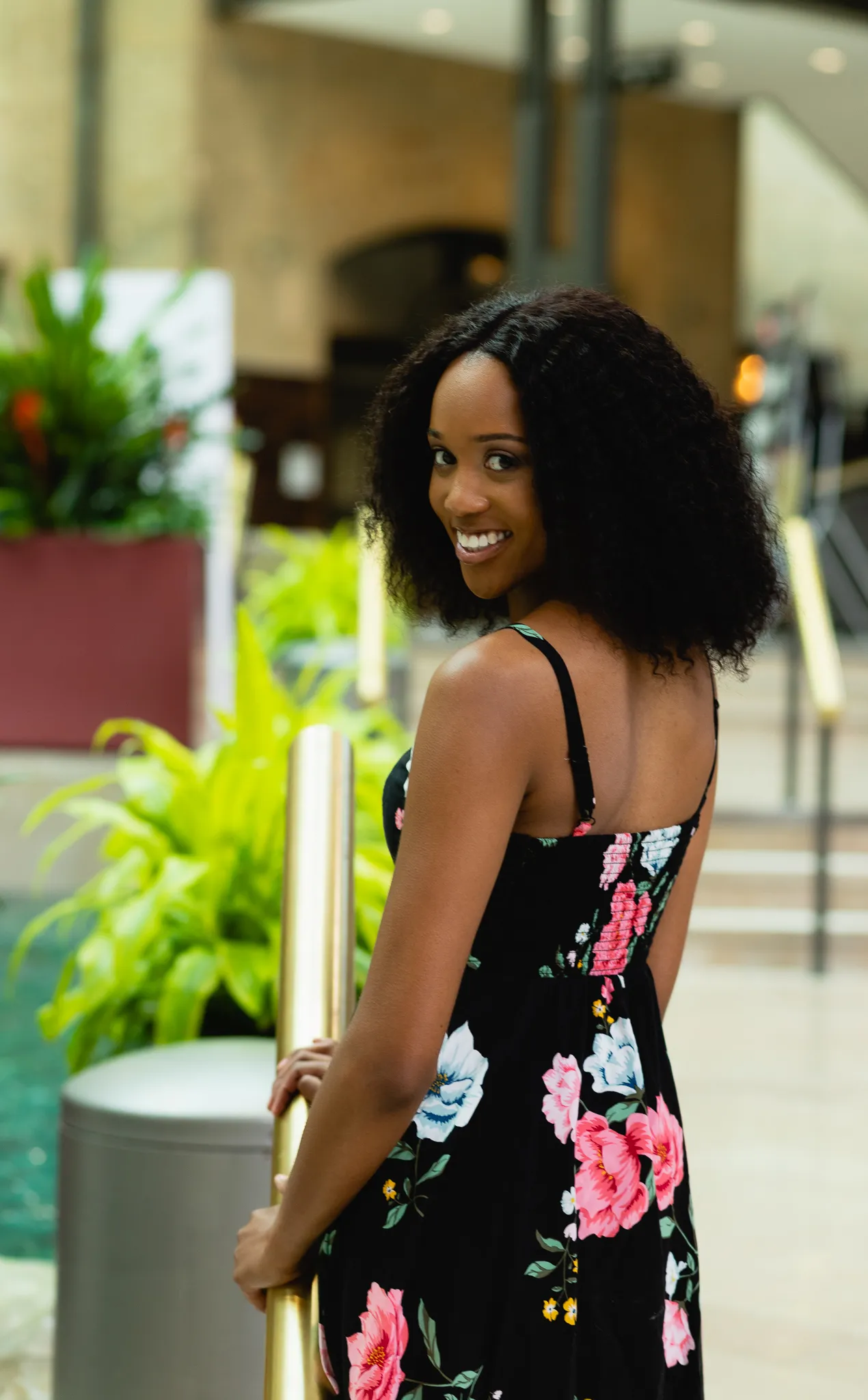 Senior glancing over her shoulder in a black floral sundress